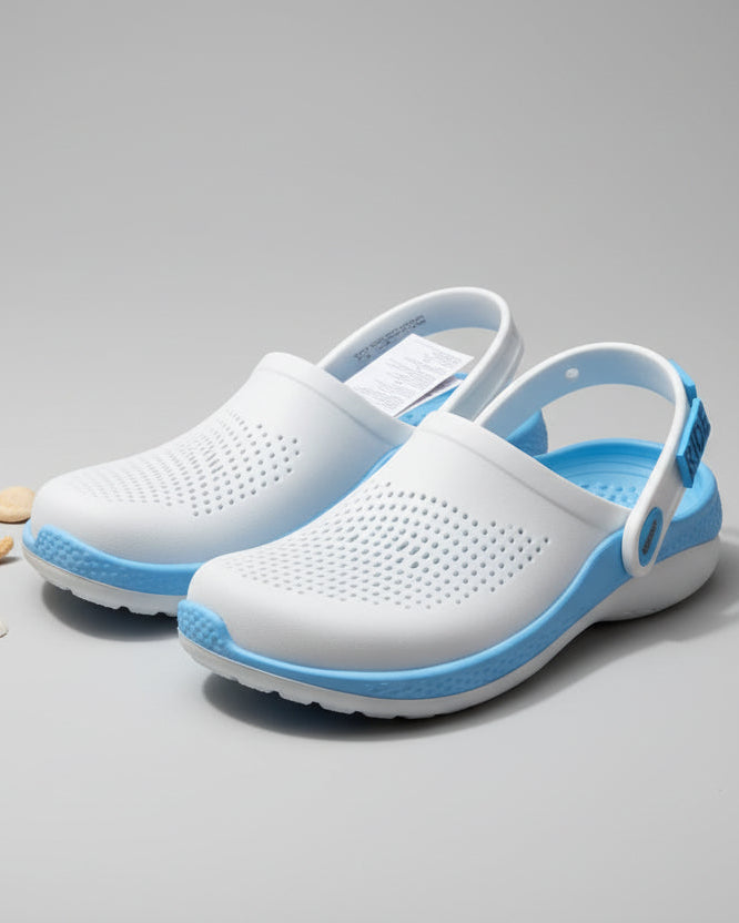White and blue shoes on a sandy beach with ocean waves in the background